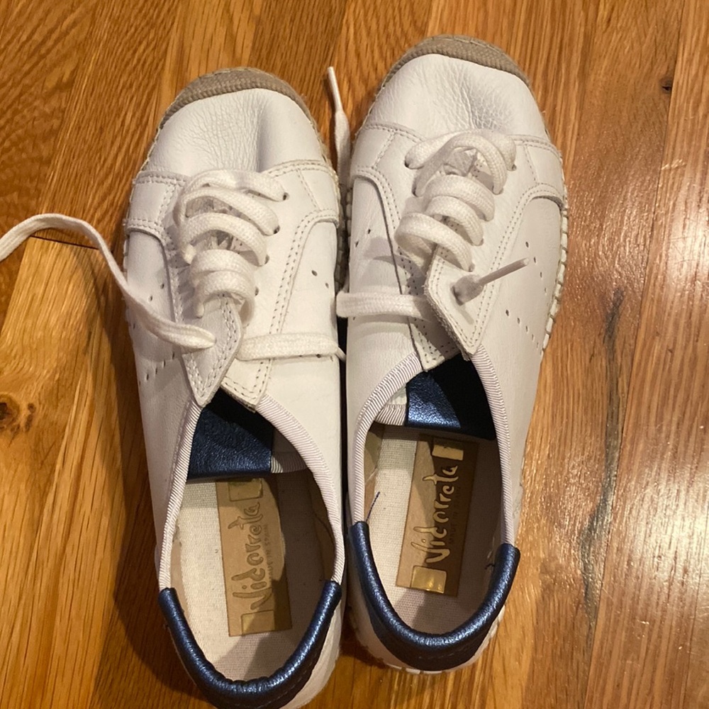 White leather espadrille sneaker with blue accents and letter “V” on sides.